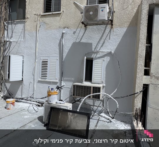 גג עם דליים, צינורות ומזגנים על קיר חיצוני